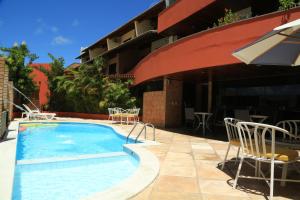 una piscina con sillas y un edificio en Garbos Soleil Hotel, en Natal