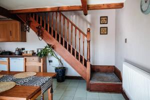 a wooden staircase in a kitchen with a table at The Old Stable at Blackshaw Farm in Leek
