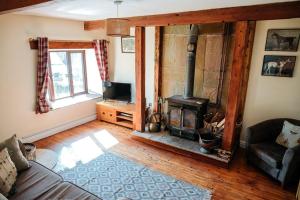 una sala de estar con estufa de leña en una casa en The Old Stable at Blackshaw Farm en Leek