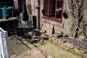 a patio with a table and chairs on a deck at The Old Stable at Blackshaw Farm in Leek