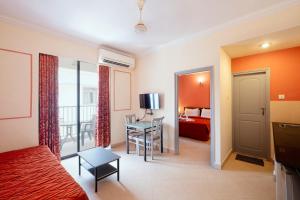 Habitación de hotel con cama, escritorio y habitación en Aastha Escape Resort near Calangute Beach, en Calangute
