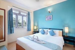 een slaapkamer met een bed met twee zwanen erop bij Aastha Escape Resort near Calangute Beach in Calangute