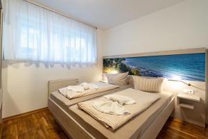 two beds in a bedroom with a painting on the wall at Villa Sand im Schuh in Ostseebad Sellin +130 photos