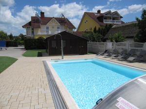 a swimming pool in front of a house at Villa Jäger in Vonyarcvashegy