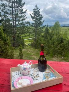 a tray with a bottle of wine and a tea pot at Bungalovi Mijakovici in Pljevlja