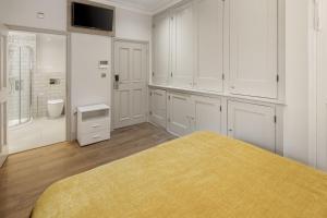 a bedroom with white cabinets and a yellow bed at Notting Hill House in London +121 photos