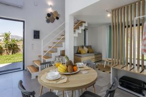 - une salle à manger et un salon avec une table et des chaises dans l'établissement Hermagio Villa George by Estia, à Mália