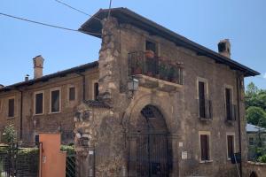 an old stone building with a door and a balcony at Caldora Apartment in LʼAquila
