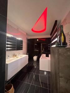 uma grande casa de banho com 2 lavatórios e um tecto vermelho em VistaMare em Marina di Schiavonea
