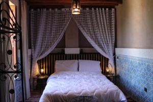 a bedroom with a white bed with a canopy at Villa DALIA Route Ourika en Exclusivité in El Jemʼa Ghemat