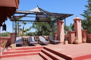 a patio with chairs and a table and a canopy at Villa DALIA Route Ourika en Exclusivité in El Jemʼa Ghemat