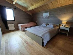Un dormitorio con una cama grande y una ventana en Le Gite des Genêts, en Coucouron