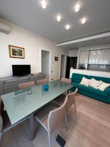 - un salon avec une table en verre et un canapé dans l'établissement Casa Roberto, à Riccione
