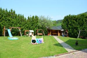 un parc avec une aire de jeux avec un toboggan et des balançoires dans l'établissement D.W MAGURKA, à Rycerka Górna