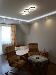 a bedroom with a bed and two chairs and a table at Willa Ewa in Poronin