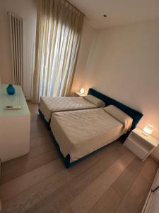 - une chambre avec un lit et une table avec deux lampes dans l'établissement Casa Roberto, à Riccione
