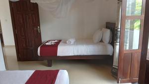 a small bedroom with a bed and a door at Villa Sanitha in Ambalangoda