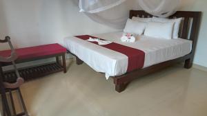 a bedroom with a bed with a teddy bear on it at Villa Sanitha in Ambalangoda