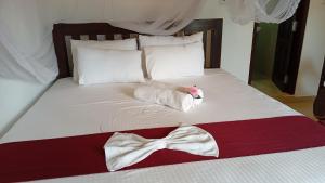 a bed with a robe and a bow tie on it at Villa Sanitha in Ambalangoda