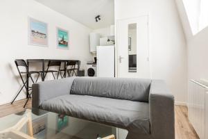 ein Wohnzimmer mit einem Sofa und einem Tisch in der Unterkunft Appartement style industriel, propre, WIFI Fibre in Roncq