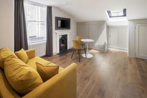 a living room with a yellow couch and a table at Notting Hill House in London