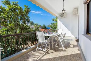 a patio with a table and chairs on a balcony at Xanthi's Dream Place in Potos