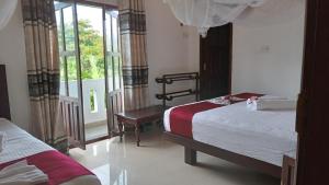 Habitación de hotel con 2 camas y ventana en Villa Sanitha, en Ambalangoda