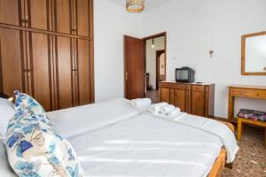 a bedroom with a large white bed and a tv at Xanthi's Dream Place in Potos +22 photos