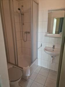 a bathroom with a shower and a toilet and a sink at Hotel Am Stuttgarter Eck in Berlin