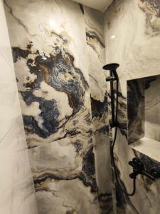 a shower in a bathroom with a marble wall at Grecos STAY SKIATHOS in Skiathos Town