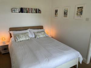a bedroom with a white bed with two pillows at 2a Coastguard Cottages in Gorran Haven