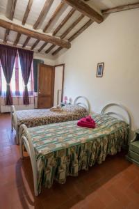 a bedroom with two beds and a table with a blanket at ROSMARINO in Città della Pieve
