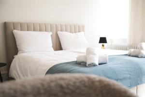 una camera con due letti con lenzuola e asciugamani bianchi di Palais Passy~Design Suite mit Ausblick im Zentrum a Wiesbaden
