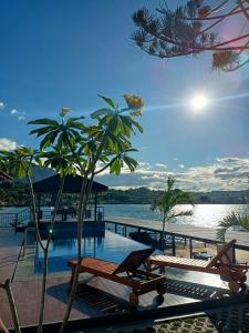 a resort with a pool and a body of water at PURNAMA BALIGE HOTEL in Balige