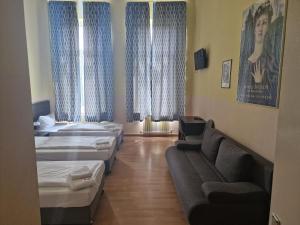 Zimmer mit 3 Betten und einem Sofa in der Unterkunft Hotel Am Stuttgarter Eck in Berlin