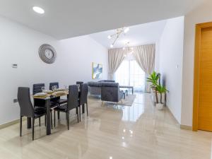 a dining room and living room with a table and chairs at Large 2BR w Wooden floor 2 min Access Highway in Dubai