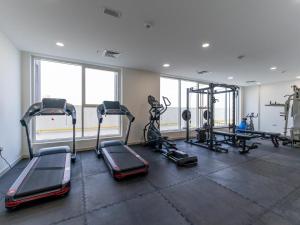 a gym with several treadmills and machines in a room at Large 2BR w Wooden floor 2 min Access Highway in Dubai