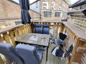 a wooden deck with a table and chairs on it at Unique antique 2BR@Hackney canal in London