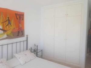 een slaapkamer met een bed en een schilderij aan de muur bij 610 precioso apartamento cerca del mar in Los Amarguillos