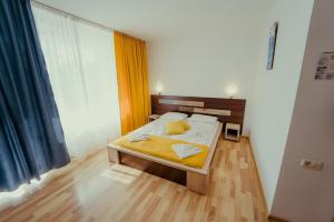 a bedroom with a bed with yellow sheets at Complex Marinn Costinesti in Costinesti