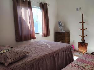 um quarto com uma cama e uma janela em Casa Unamar Cabo Frio-RJ em Cabo Frio