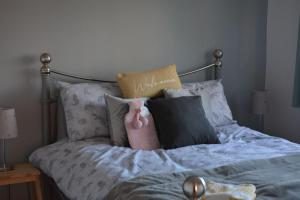a bed with pillows and a pink stuffed animal on it at 2 Barbour Court in Lisburn