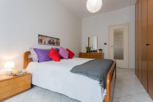 um quarto com uma grande cama branca com almofadas coloridas em A Casa di Enza by Wonderful Italy em Turim