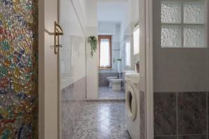 uma casa de banho com um WC, uma janela e uma porta em A Casa di Enza by Wonderful Italy em Turim