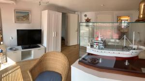una sala de estar con una mesa con un barco modelo en Sønderstrand Bed & Breakfast Skagen, en Skagen