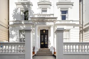 a white house with white columns and a black door at Notting Hill House in London