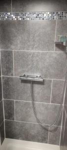 a shower with a hose attached to a tile wall at French Horn Chalets in Alton