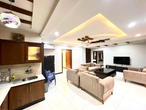 a living room with couches and a tv and a kitchen at LUXURY 6 Bedroom Holiday Home in Islamabad