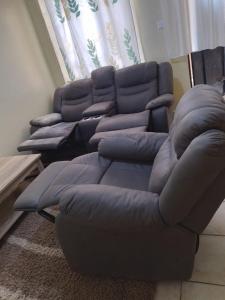 a living room with two couches and a couch at Lux Suites Lumumba Drive Apartments in Nairobi