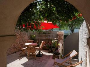 een patio met een tafel en stoelen en een parasol bij Gite les trois matelots in Fécamp